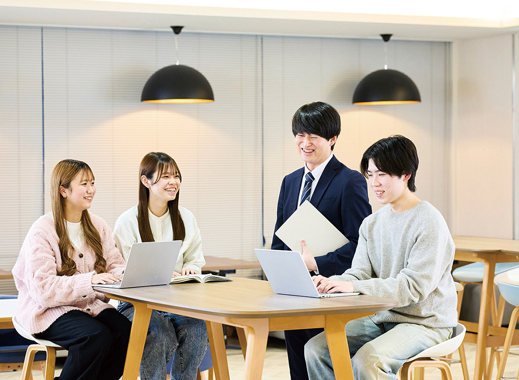 3人の学生と職員が話す様子